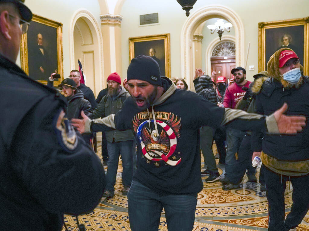 The congressional committee investigating the Jan. 6, 2021 attack on the Capitol will focus on the role of QAnon and extremist groups like the Oath Keepers and Proud Boys in its upcoming hearing. Prosecutors have identified the man at the center of this photograph as a QAnon-supporter named Douglas Jensen. Jensen has pleaded not guilty to all charges. The congressional committee investigating the Jan. 6, 2021 attack on the Capitol will focus on the role of QAnon and extremist groups like the Oath Keepers and Proud Boys in its upcoming hearing. Prosecutors have identified the man at the center of this photograph as a QAnon-supporter named Douglas Jensen. Jensen has pleaded not guilty to all charges. (Manuel Balce Ceneta/AP)