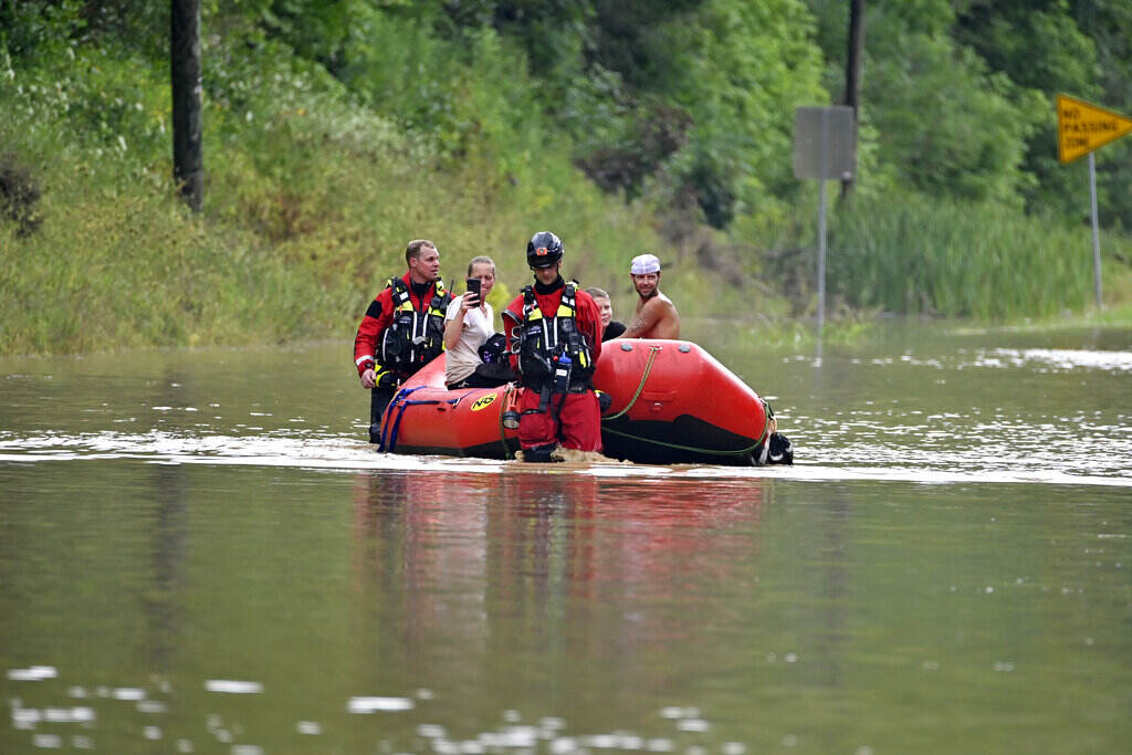 Severe Weather Appalachia Search and rescue team is in a red boat in a flooded area.