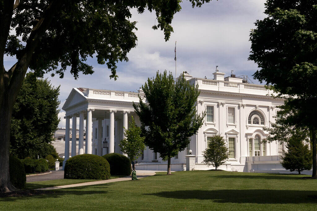 Virus Outbreak Biden Rebound The White House is seen from afar, surrounded by trees.