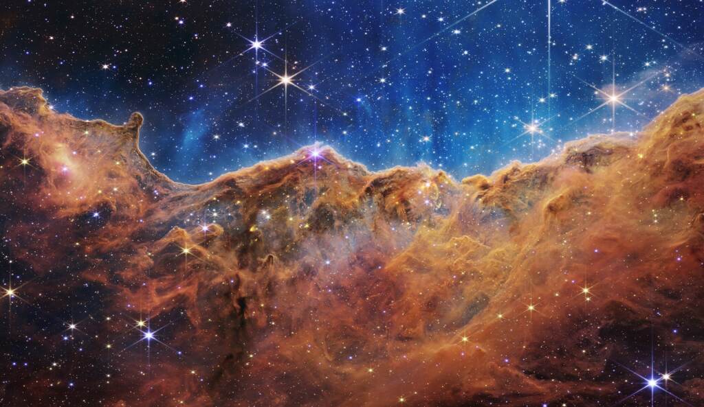 What looks much like craggy mountains on a moonlit evening is actually the edge of a nearby, young, star-forming region NGC 3324 in the Carina Nebula. Captured in infrared light by the Near-Infrared Camera (NIRCam) on NASA’s James Webb Space Telescope, this image reveals previously obscured areas of star birth. The edge of a nearby, young, star-forming region NGC 3324 in the Carina Nebula