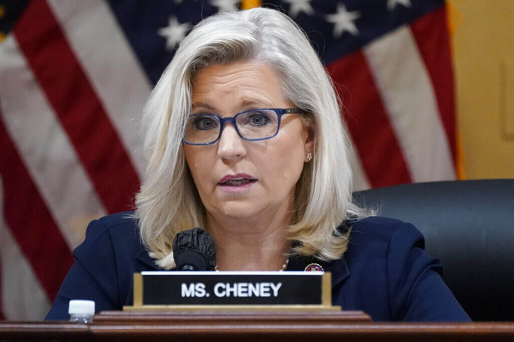 Liz Cheney Rep. Liz Cheney speaks, her nameplate visible in front of her, with an American flag visible in the background.