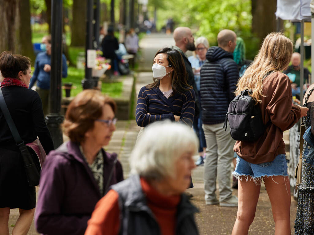 PORTLAND, OR – May 4th, 2022: On Wednesday, May 4th, 2022 a mix People walk on a sidewalk, masked.