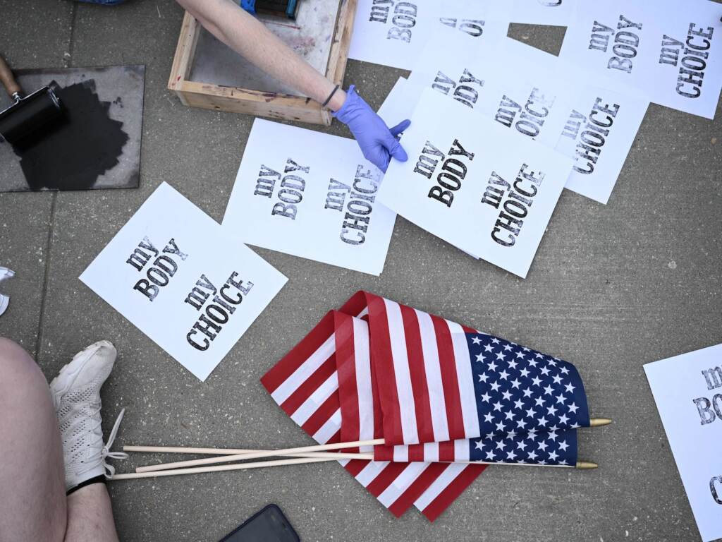Signs reading ''My body my choice'' are seen from above at an abortion rights protest