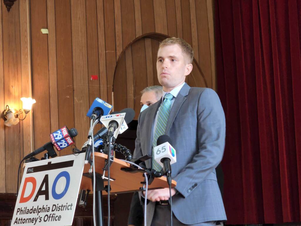 ghost-gun-arrest-palmer-ada A man stands at a podium with a sign reading DAO in front of him.