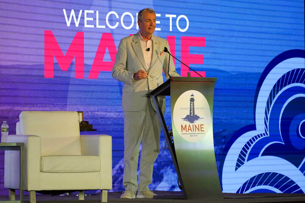 Phil Murphy Gov. Phil Murphy stands at a podium on a stage with a Welcome to Maine sign in the background.