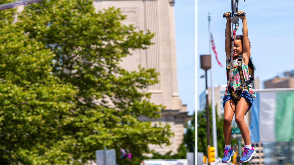 julyfourth2022-parkwayfestival-33crop A child smiles while using a zip line set on the Ben Franklin Parkway.