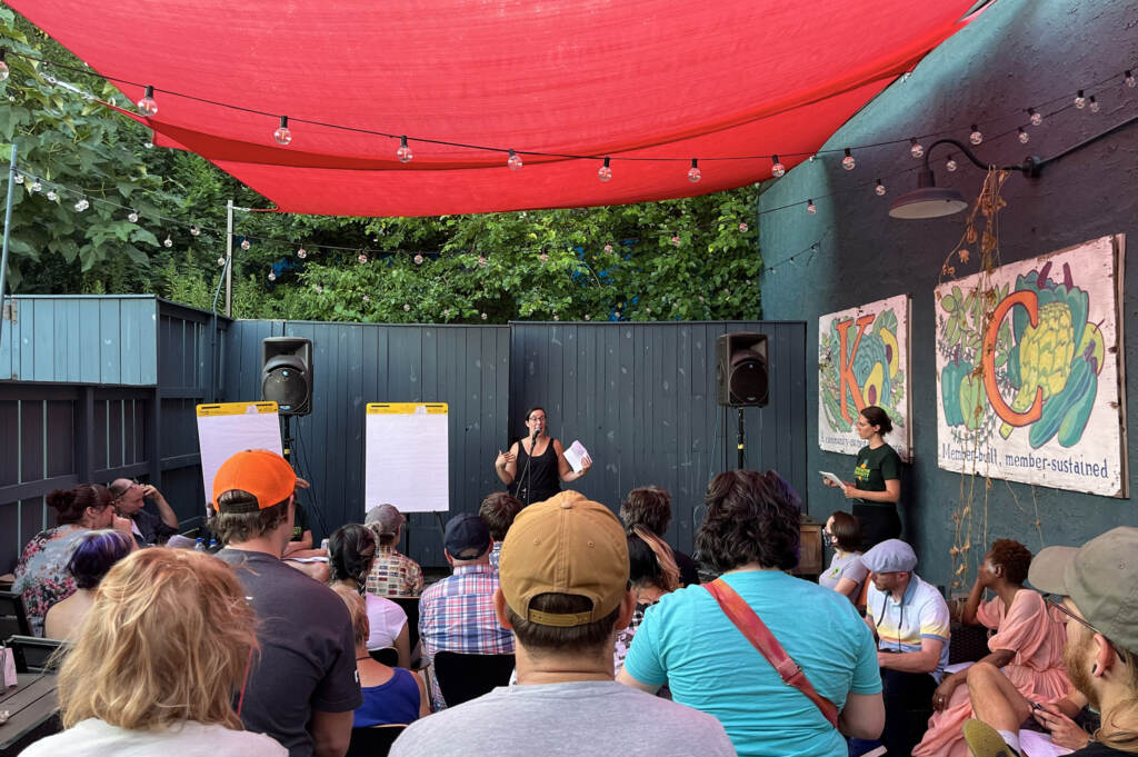A person speaks in front of a crowd.