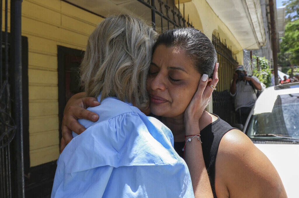 Honduras Migrant Deaths A woman cries as she is embraced by another person.