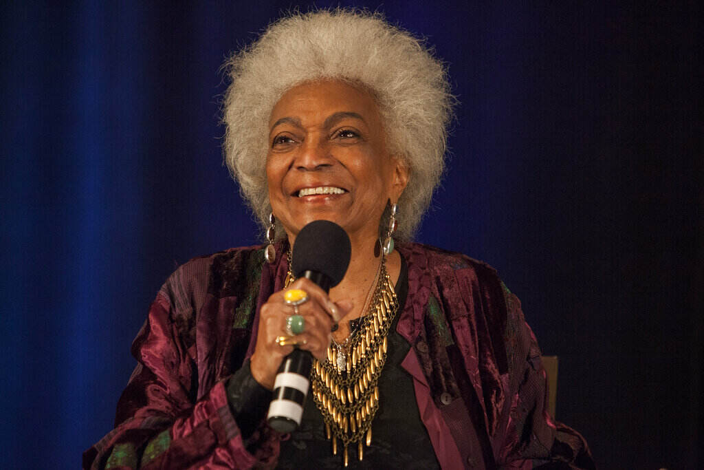 Up-close photo of Nichelle Nichols speaking with microphone in hand.