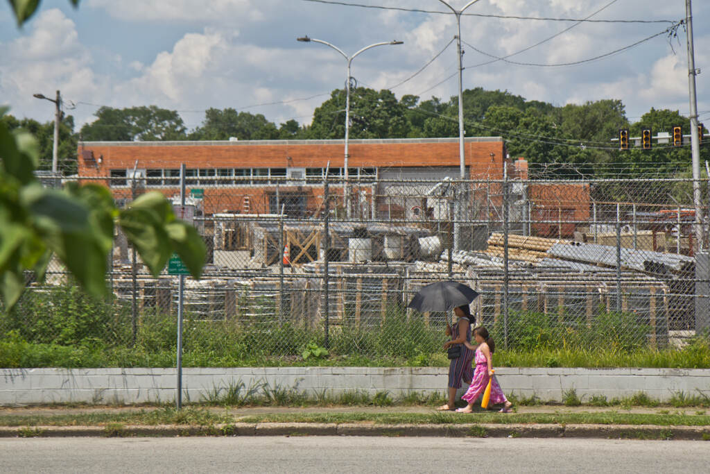 2022 07 20 k paynter heat photos 2022 (1 of 1)-2 A woman uses an umbrella for protection from the sun as she walks along with a child