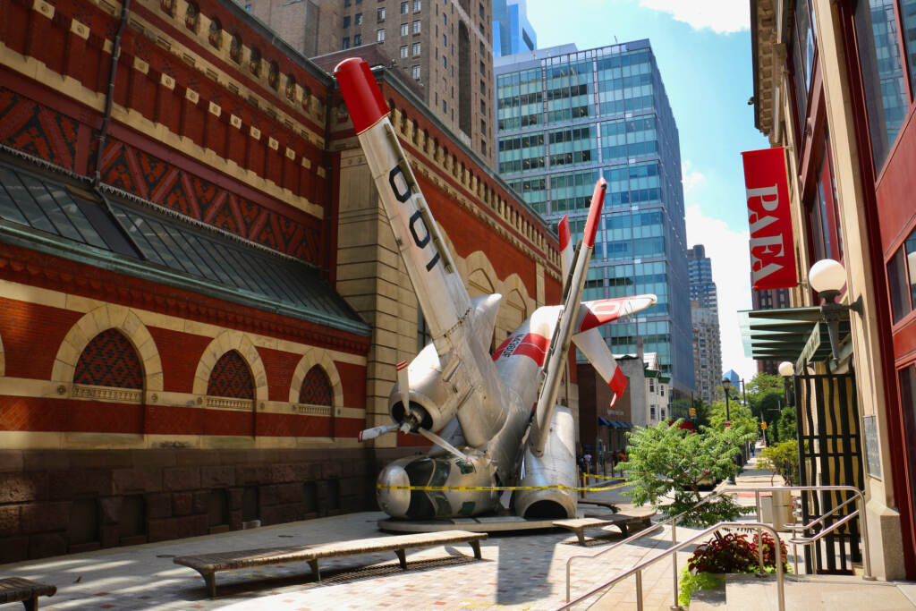 2022 08 04-e lee-philadelphia pafa lenfest plaza-grumman greenhouse ''Grumman Greenhouse'' has occupied Lenfest Plaza at the Pennsylvania Academy of Fine Arts since 2011. The sculpture features a Navy war plane that has been converted into a greenhouse. (Emma Lee/WHYY)