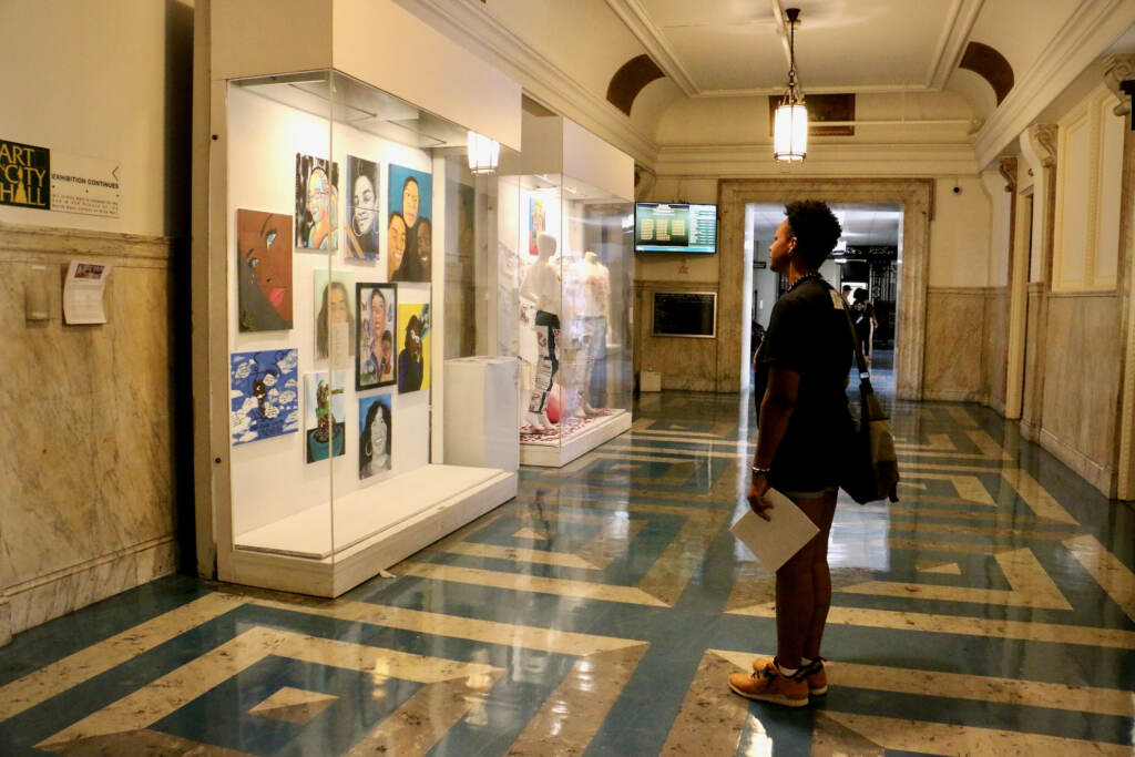 2022 08 11-e lee-philadelphia city hall-we are here exhibit visitor File photo: Portraits of loved ones of shooting victims, called co-victims, are displayed on three floors at Philadelphia City Hall in an exhibit curated by Zarinah Lomax called ''We Are Here: Stories and Expressions of Healing.'' (Emma Lee/WHYY)