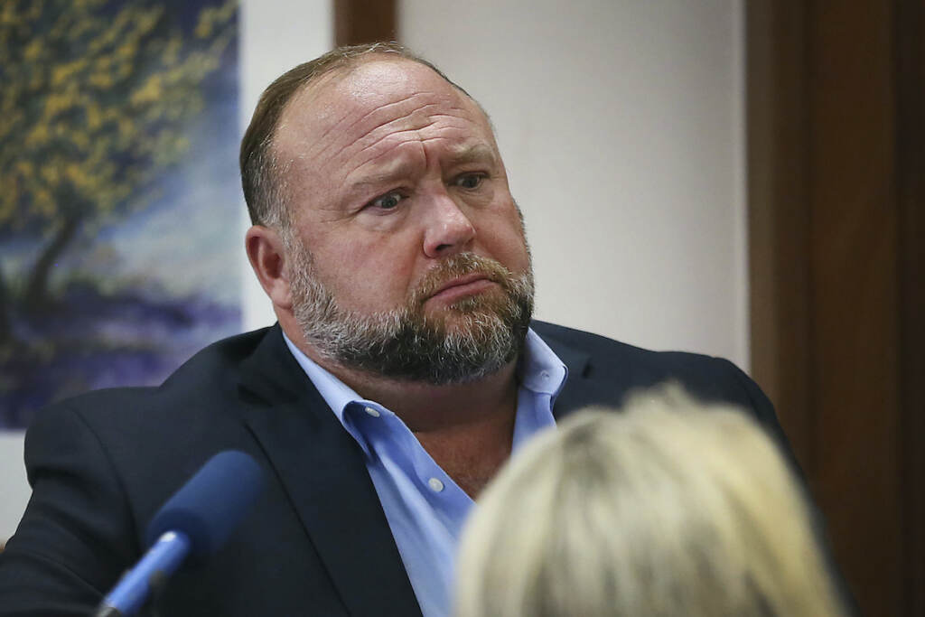 APTOPIX Newtown Shooting-Infowars Conspiracy theorist Alex Jones attempts to answer questions about his emails asked by Mark Bankston, lawyer for Neil Heslin and Scarlett Lewis, during trial at the Travis County Courthouse in Austin, Wednesday Aug. 3, 2022. (Briana Sanchez/Austin American-Statesman via AP, Pool)