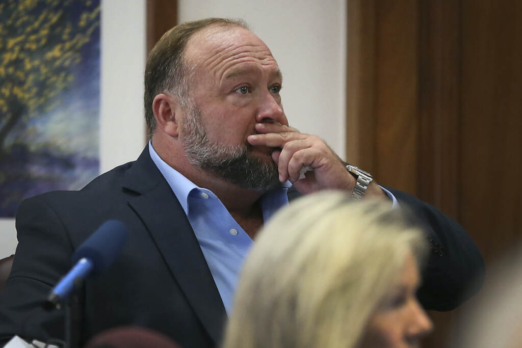 Newtown Shooting-Infowars Alex Jones attempts to answer questions about his text messages asked by Mark Bankston, lawyer for Neil Heslin and Scarlett Lewis, during trial at the Travis County Courthouse in Austin, Wednesday Aug. 3, 2022. (Briana Sanchez/Austin American-Statesman via AP, Pool)