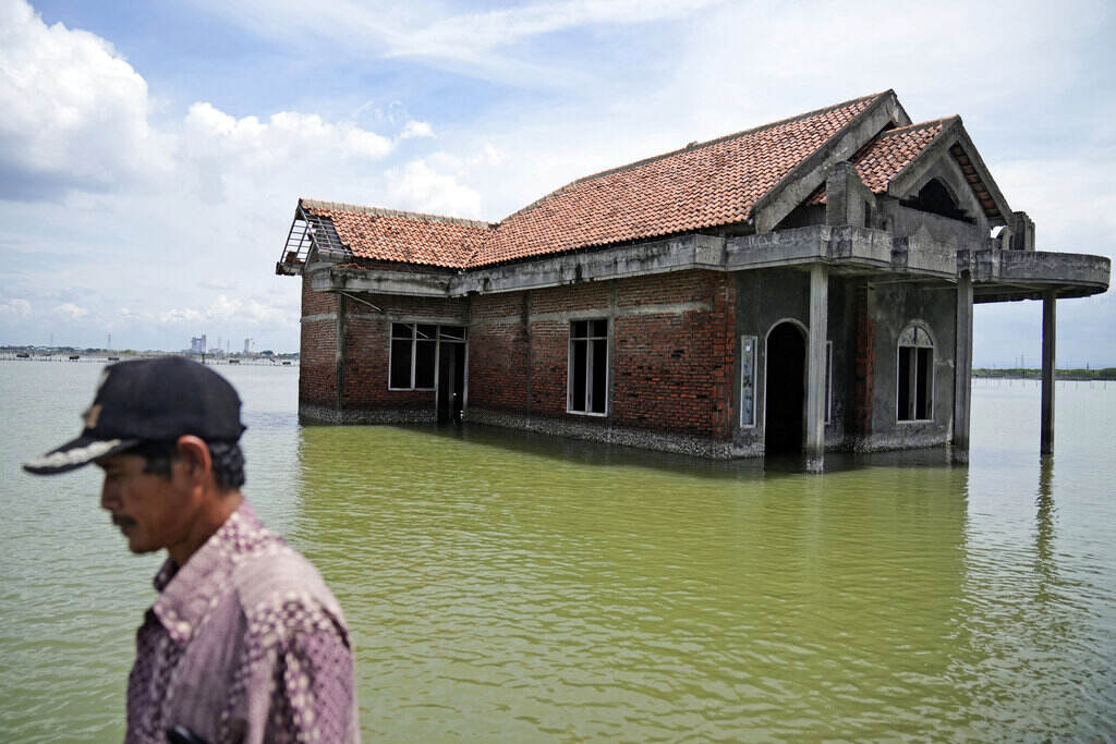 Climate Diseases A man is shown in profile in the foreground. In the background is water surrounding a house.