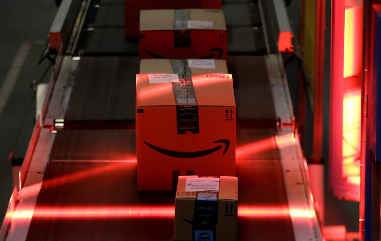 File photo: Packages riding on a belt are scanned to be loaded onto delivery trucks at the Amazon Fulfillment center. (AP Photo/Julio Cortez, File)
