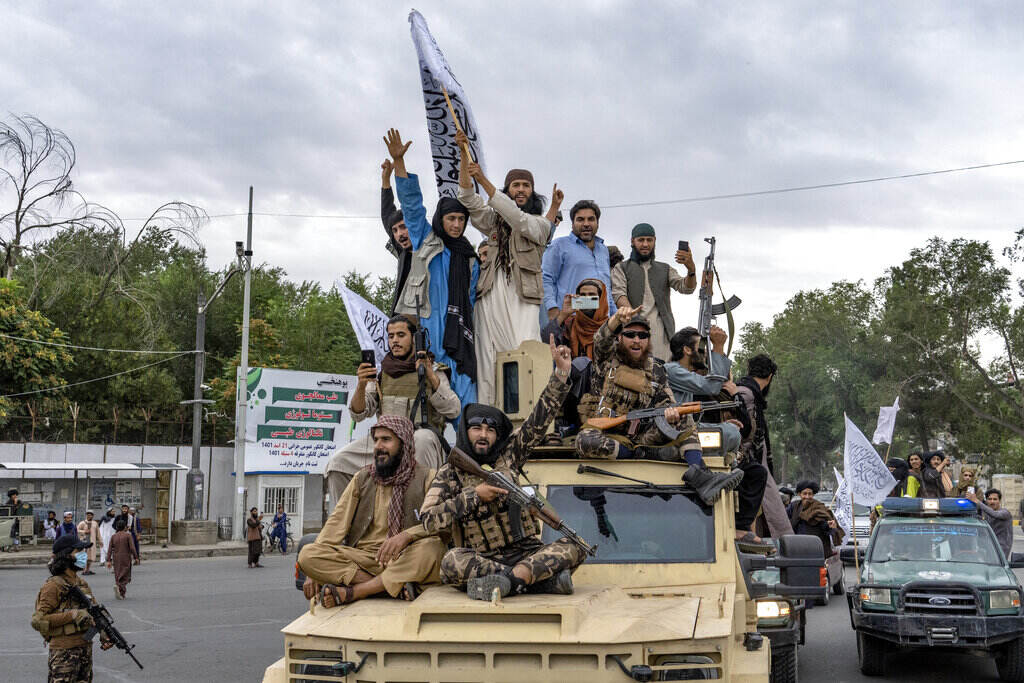 Afghanistan Taliban fighters celebrate one year since they seized the Afghan capital, Kabul, in front of the U.S. Embassy in Kabul, Afghanistan, Monday, Aug. 15, 2022. The Taliban marked the first-year anniversary of their takeover after the country's western-backed government fled and the Afghan military crumbled in the face of the insurgents' advance. (AP Photo/Ebrahim Noroozi)