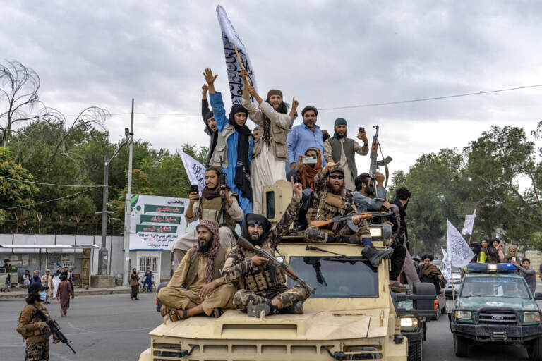Taliban fighters celebrate one year since they seized the Afghan capital, Kabul, in front of the U.S. Embassy in Kabul, Afghanistan, Monday, Aug. 15, 2022. The Taliban marked the first-year anniversary of their takeover after the country's western-backed government fled and the Afghan military crumbled in the face of the insurgents' advance. (AP Photo/Ebrahim Noroozi)