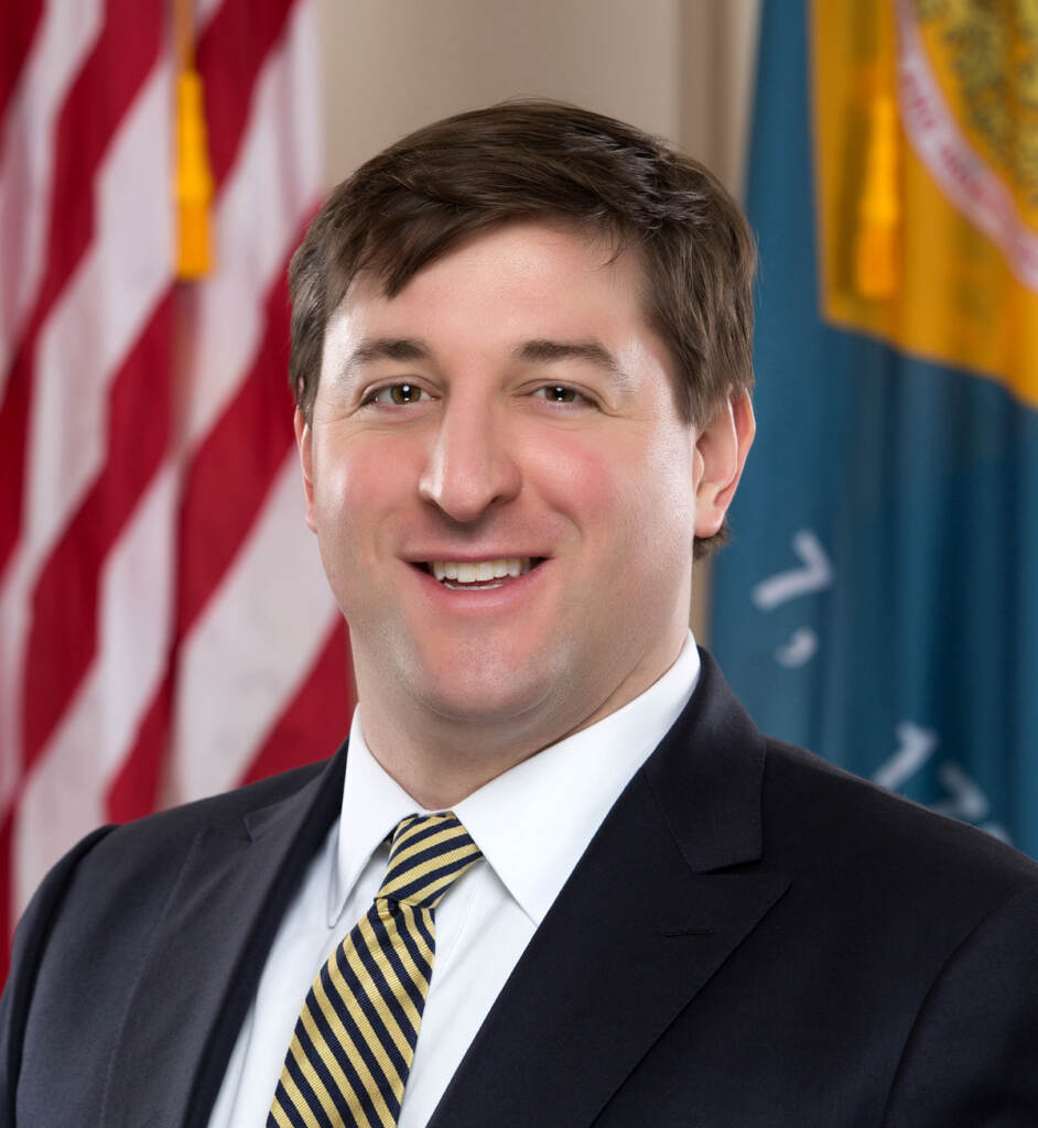 A headshot of state Sen. Bryan Townsend with the American flag visible in the background.