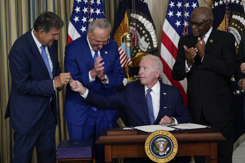 President Joe Biden hands the pen he used to sign the Democrats' landmark climate change and health care bill to Sen. Joe Manchin, D-W.Va., in the State Dining Room of the White House in Washington, Tuesday, Aug. 16, 2022. (AP Photo/Susan Walsh)