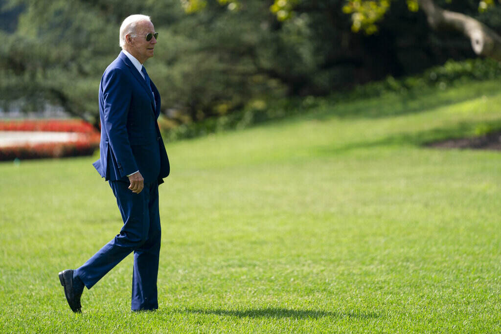 Joe Biden President Joe Biden walks across a green lawn.