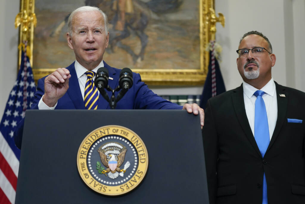 Biden Student Loans President Joe Biden speaks about student loan debt forgiveness in the Roosevelt Room of the White House. Education Secretary Miguel Cardona listens at right.