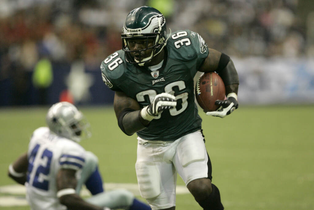 Philadelphia Eagles running back Brian Westbrook runs with the ball as Dallas Cowboys cornerback Terence Newman sits on the turf