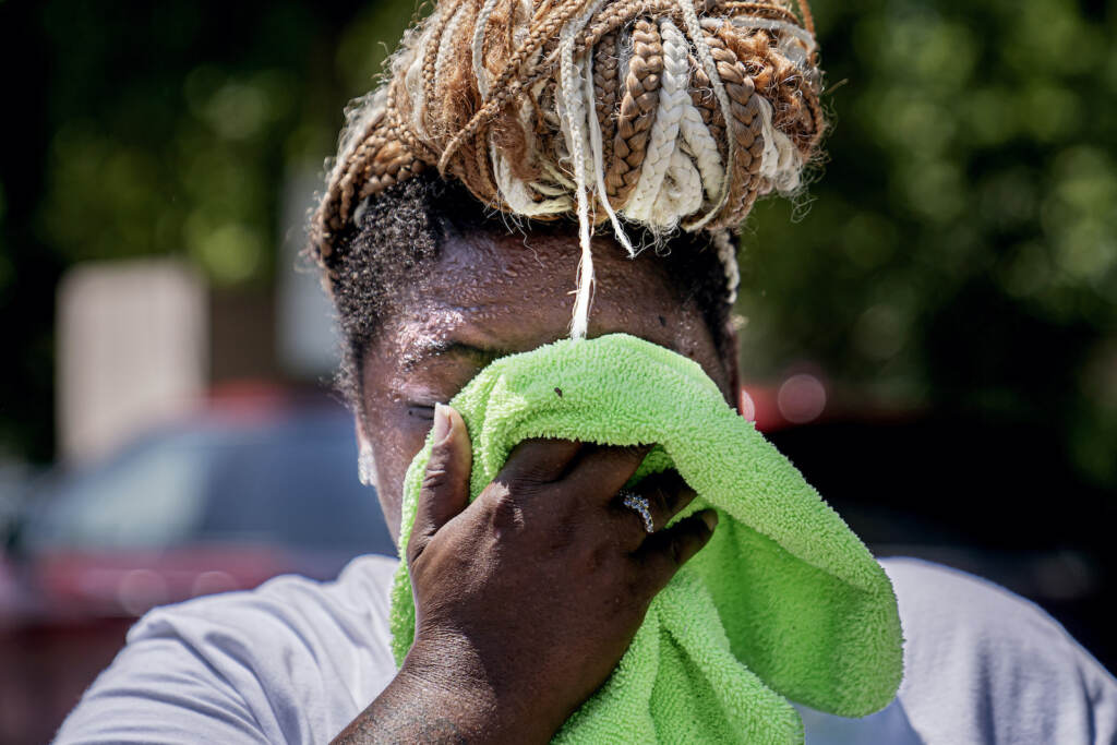Future Heat Waves FILE - Nicole Brown wipes sweat from her face while setting up her beverage stand near the National Mall on July 22, 2022, in Washington. What's considered officially 'dangerous heat' in coming decades will likely hit much of the world at least three times more often as climate change worsens, according to a new study. (AP Photo/Nathan Howard, File)