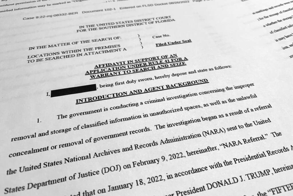 Trump FBI The affidavit by the FBI in support of obtaining a search warrant for former President Donald Trump's Mar-a-Lago estate is photographed Friday, Aug. 26, 2022. U.S. Magistrate Judge Bruce Reinhart ordered the Justice Department to make public a redacted version of the affidavit it relied on when federal agents searched Trump's estate to look for classified documents. (AP Photo/Jon Elswick)