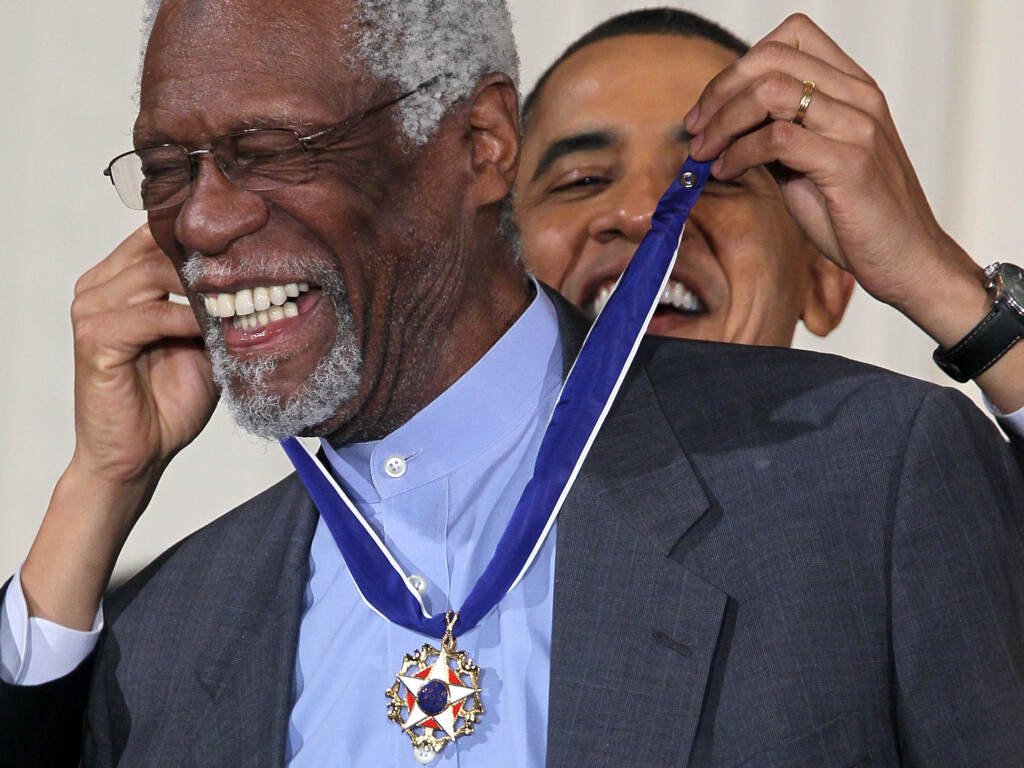 President Barack Obama awards Bill Russell the Presidential Medal of Freedom in 2011. The president recognized Russell not just for his legendary basketball career, but for his work as an activist on and off the court. Bill Russell smiles as President Barack Obama is visible putting a medal around his neck.