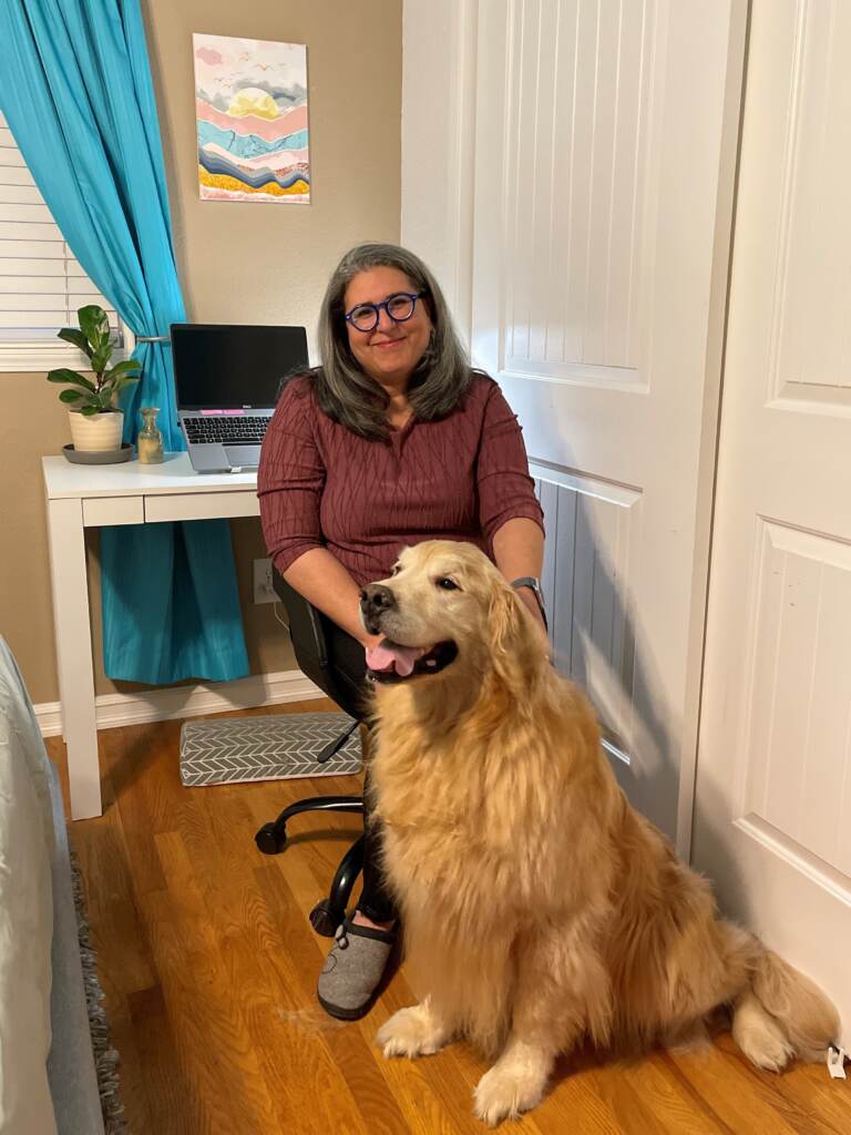 Jenn Ramirez Robson sits in a chair next to her dog, Dickens