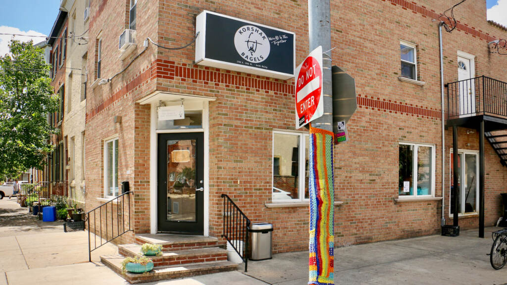 A view of the exterior of Korshak Bagels, a red brick building.