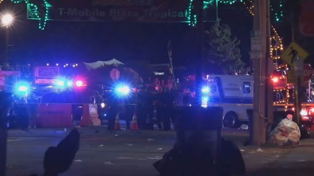 Police lights and vehicles are visible in the darkness.