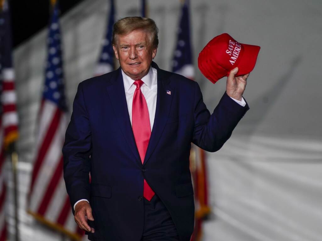 Election 2022 Wisconsin Governor Former President Donald Trump holds up a red hat while on stage at a rally