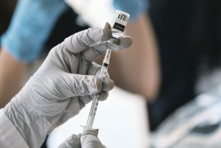 A pharmacist loads a syringe with the monkeypox vaccine