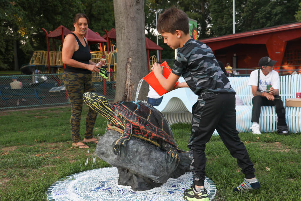 2022 09 14 K PAYNTER River Alive! Learning Trail number3 Richard Feliciano Velez, 7, tests the water feature of the River Alive! Learning Trail turtle sculpture after the unveiling event at Tookany Creek Park on Sept. 14, 2022. (Kimberly Paynter/WHYY)