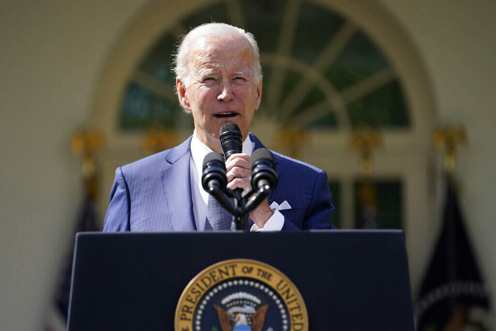 Joe Biden President Biden holds a microphone as he speaks from behind a podium outdoors.