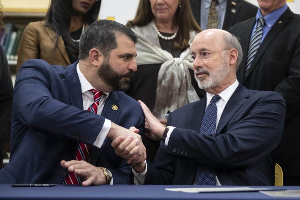 AP_19330581213880-1620×1080 File photo: Pennsylvania Gov. Tom Wolf, right, shakes hands with Rep. Mark Rozzi, D-Berks, after signing legislation into law at Muhlenberg High School in Reading, Pa., Tuesday, Nov. 26, 2019. Wolf approved legislation Tuesday to give future victims of child sexual abuse more time to file lawsuits and to end time limits for police to file criminal charges. (Matt Rourke / AP Photo)