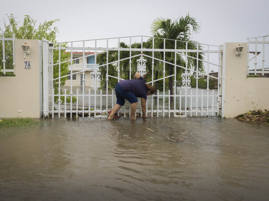 A woman clears debris on her property flooded by Hurricane Fiona in Salinas, Puerto Rico, Monday, Sept. 19, 2022. (Alejandro Granadillo/AP)