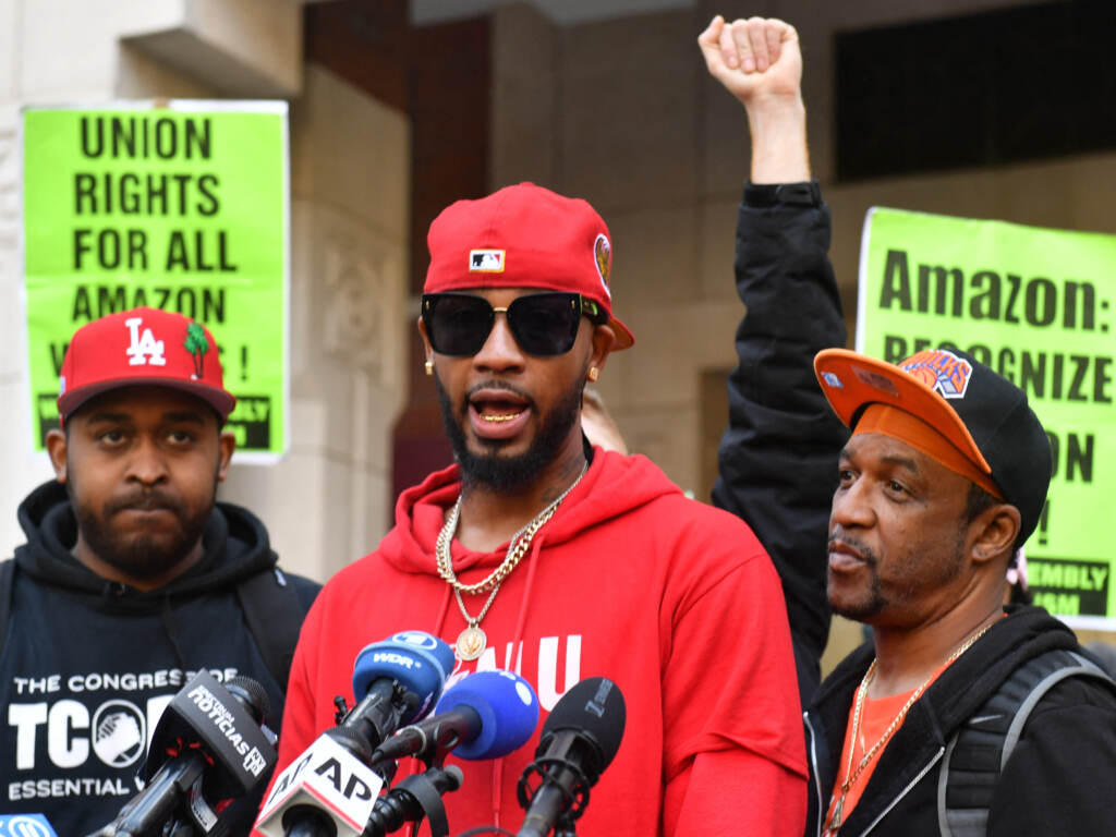 Organizer Chris Smalls speaks after his Amazon Labor Union won a vote to form the company’s first unionized U.S. warehouse in Staten Island, N.Y., in April. A person speaks at a microphone with people cheering behind him.