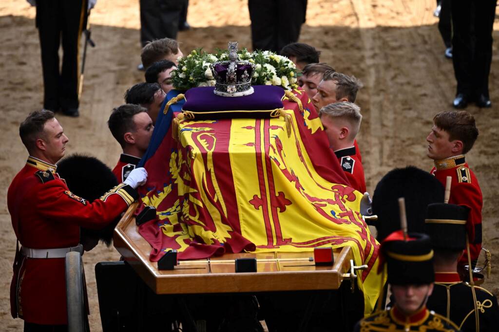 Pallbearers from the Queen's Company, 1st Battalion Grenadier Guards, prepare to carry the coffin of Queen Elizabeth II into Westminster Hall at the Palace of Westminster in London on Wednesday to lie in state following a procession from Buckingham Palace. Elizabeth's funeral is Monday. (Ben Stansall/Pool/AFP via Getty Images)