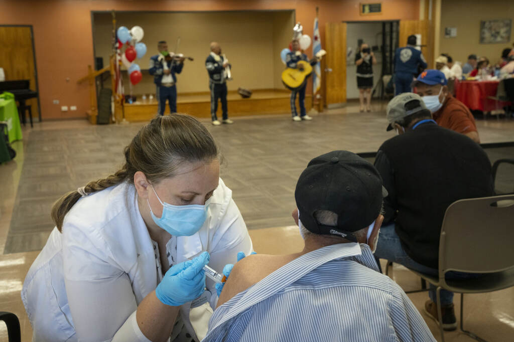 A pharmacist administers the newest COVID-19 vaccine during a clinic for seniors at the Southwest Senior Center earlier this month in Chicago. Pharmacist Patricia Pernal administers the newest COVID-19 vaccine during a clinic