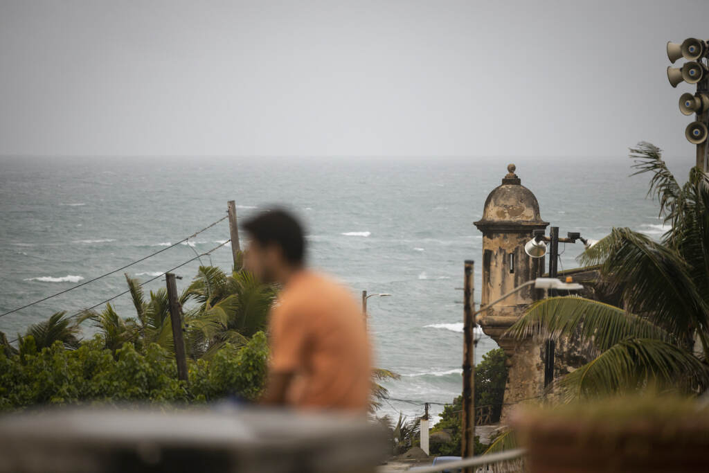 Puerto Rico Tropical Weather A man stands in front of a beach before the arrival of Tropical Storm Fiona in San Juan, Puerto Rico, Saturday, Sept. 17, 2022. Fiona was expected to become a hurricane as it neared Puerto Rico on Saturday, threatening to dump up to 20 inches (51 centimeters) of rain as people braced for potential landslides, severe flooding and power outages. (AP Photo/Alejandro Granadillo)
