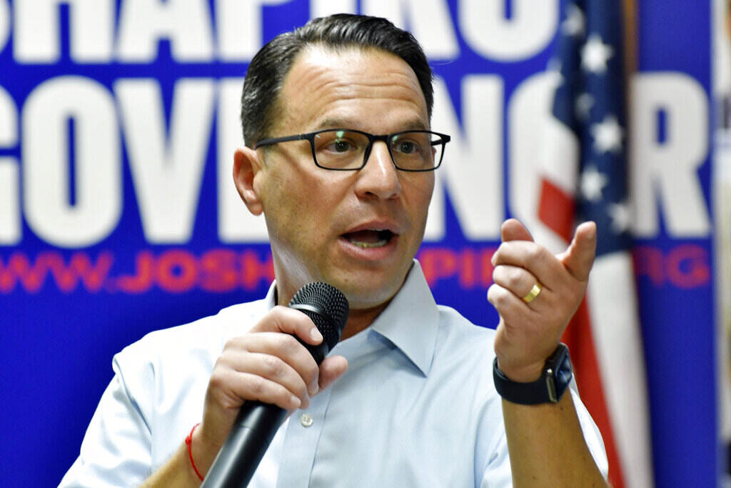 Election 2022 Pennsylvania Governor Josh Shapiro holds a microphone and gestures.