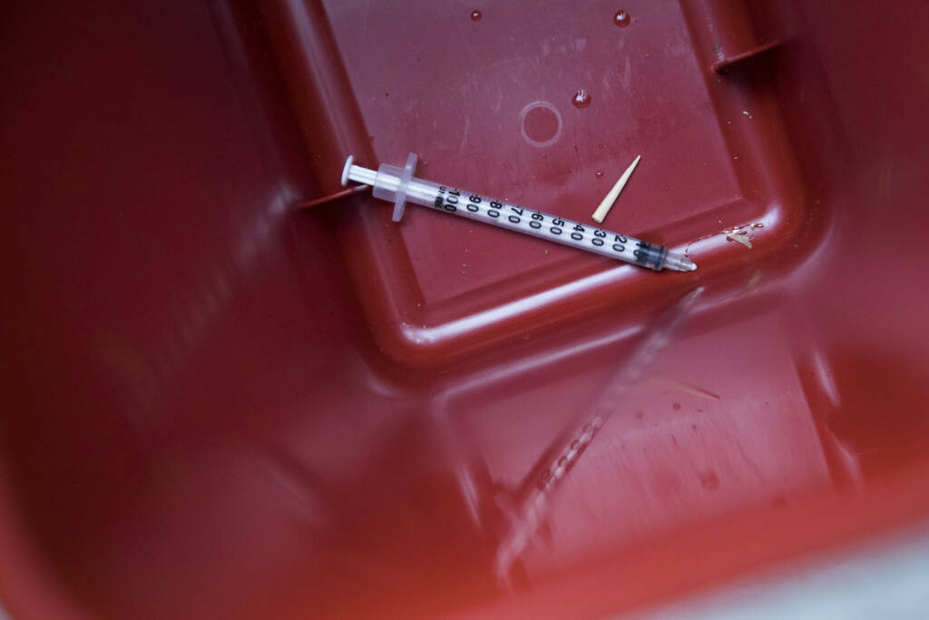 In this Tuesday, July 3, 2018, photo, a used syringe is seen in a disposal container. (AP Photo/Mary Altaffer)