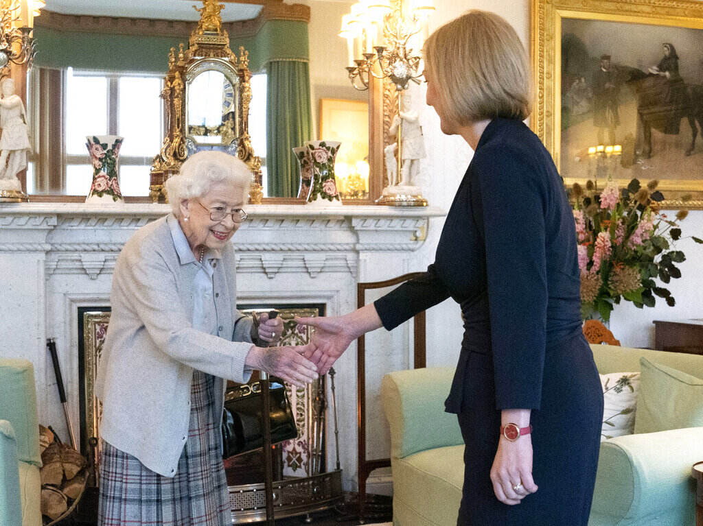APTOPIX Britain Politics Queen Elizabeth, facing the camera, shakes the hand of Liz Truss, who is faced away from the camera.