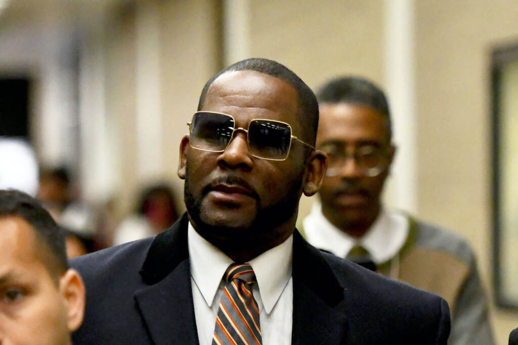 R Kelly FILE - Musician R. Kelly, center, leaves the Daley Center after a hearing in his child support case on May 8, 2019, in Chicago. Closing arguments are scheduled Monday, Sept. 12, 2022 for R. Kelly and two co-defendants in the R&B singer’s trial on federal charges of trial-fixing, child pornography and enticing minors for sex, with jury deliberations to follow. (AP Photo/Matt Marton, File)