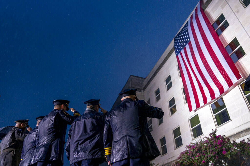 Sept 11 Anniversary A view of officers from behind saluting the American flag.