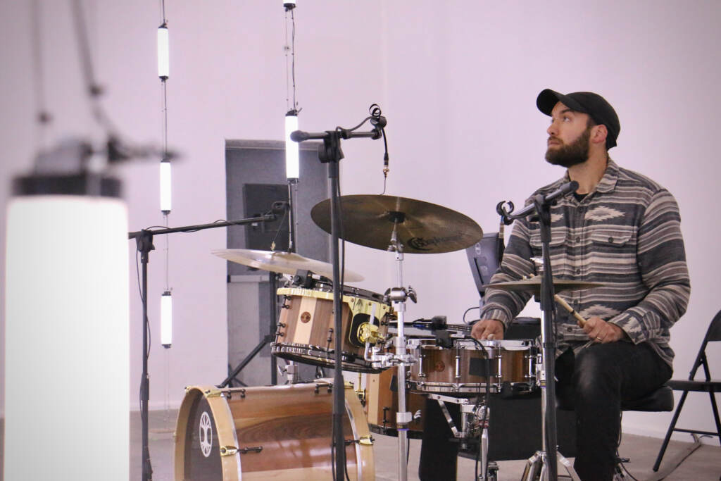 Audiovisual artist  Ezra Masch plays the drum set that is part of his installation at the Icebox in Kensington. The 300 LED lights that fill the space respond to the playing of the drum. (Emma Lee/WHYY)