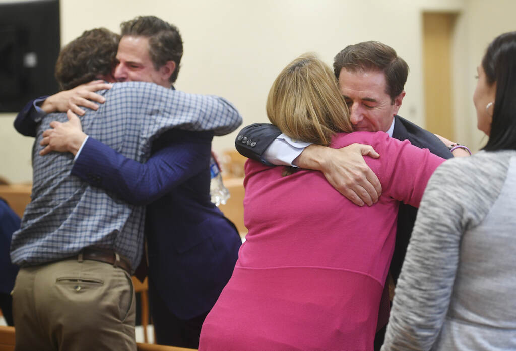 APTOPIX Newtown Shootings Infowars Plaintiff William Sherlach, left, hugs attorney Josh Koskoff while plaintiff Nicole Hockley hugs attorney Chris Mattei following the jury verdict and reading of monetary damages in the Alex Jones defamation trial at Superior Court, Wednesday, Oct. 12, 2022, in Waterbury, Conn. (Brian A. Pounds/Hearst Connecticut Media via AP, Pool)
